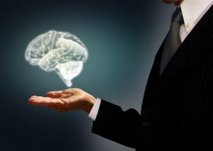 Businessman holding a virtual brain in the palm - Skills concept